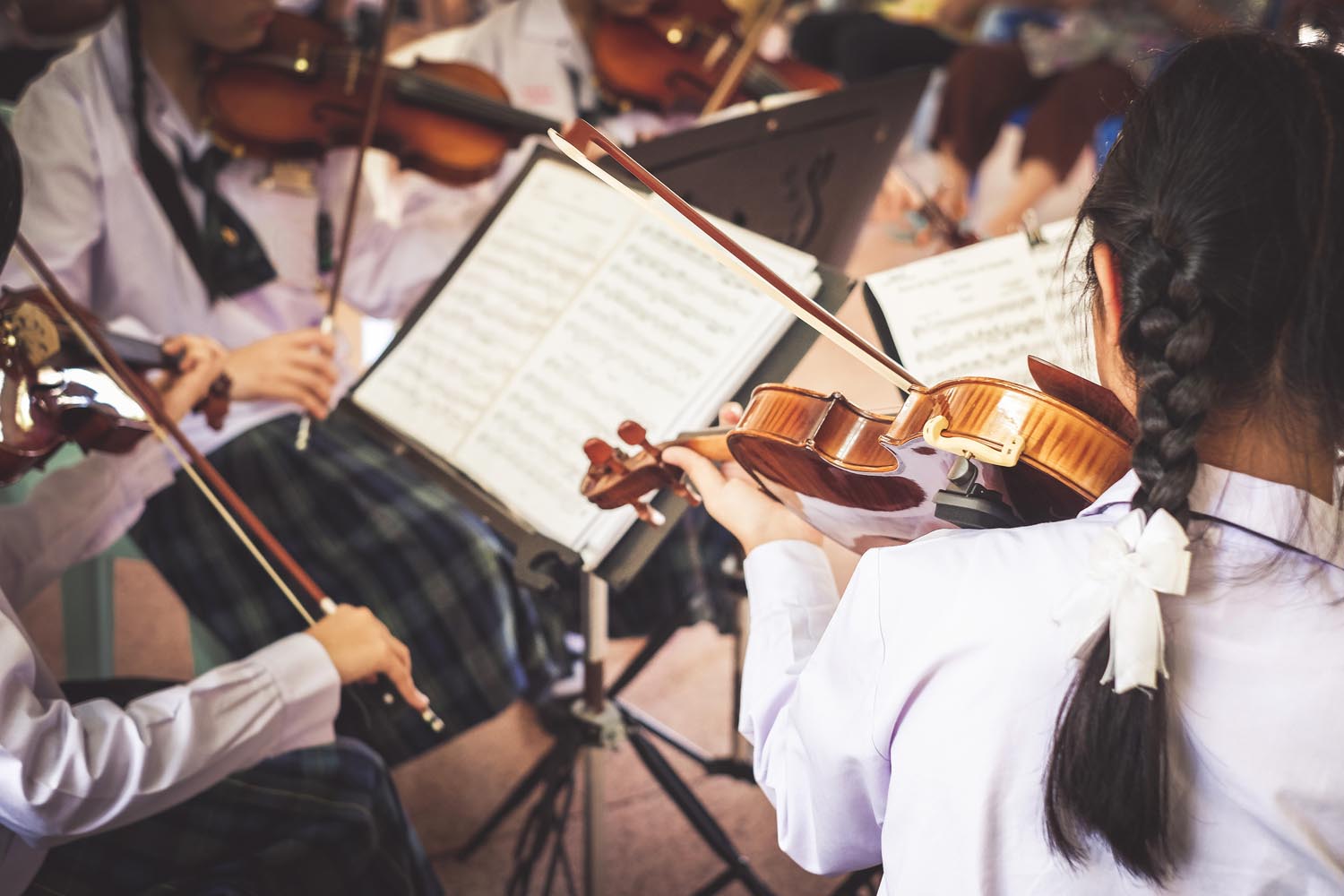 students playing violin in a group